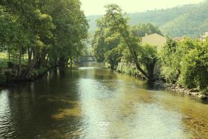 a river with trees on the side of it at Refúgio do Alva - Serra da Estrela in Seia +3 photos