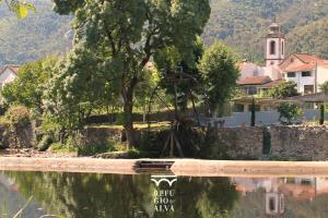 a reflection of a tree in a body of water at Refúgio do Alva - Serra da Estrela in Seia