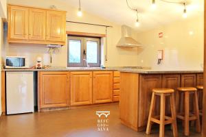 a kitchen with wooden cabinets and a counter top at Refúgio do Alva - Serra da Estrela in Seia