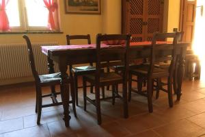 - une table à manger en bois avec des chaises et une table dans l'établissement Casa a schiera fronte lago con giardino, à Barcis