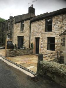an old stone building with a courtyard in front of it at Squirrel cottage in Cowling