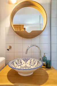 a sink in a bathroom with a round mirror at Fischerhus Ummanz FW2 in Ummanz