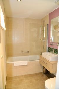 a bathroom with a tub, sink, toilet and bathtub at New Orly in Munich