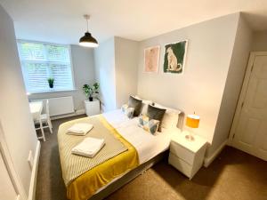 a small bedroom with a bed with a yellow blanket at South cliff Apartment with Garden in Scarborough