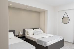 two beds in a white room with a mirror at Casa Di Mare II in Olympic Beach