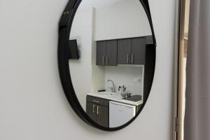 a mirror reflecting a kitchen with a sink and cabinets at Casa Di Mare II in Olympic Beach +52 photos