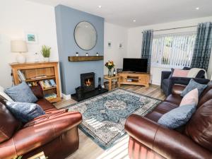 a living room with a couch and a fireplace at Bryn Hafod in Cemaes Bay