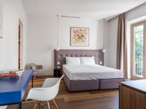 una camera con un letto, una scrivania blu e un tavolo di numa I Vita Apartments a Firenze
