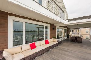 a couch on a porch with red pillows at Lago-mar Luxury Modern Waterfront Home in Atlantic City