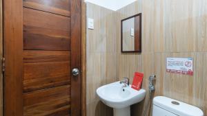 a bathroom with a sink and a toilet and a door at RedDoorz at DBuilders Rooms Ph1 Taguig in Manila +31 photos