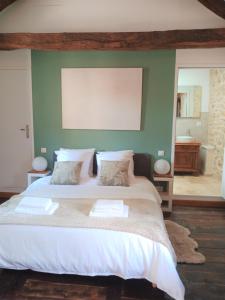 a bedroom with a large bed with a green wall at Les granges de l abbaye in Ginals