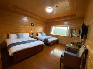 Dormitorio con 2 camas y cabina con TV en Lala Maple Villa, en Hualing