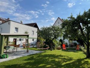 uma casa com um quintal com cadeiras e árvores em Ferien-Apartment Beller em Strullendorf