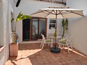 une terrasse avec une table, des chaises et un parasol dans l'établissement Encantadora casa rural con piscina privada, à El Bosque