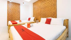 two beds in a room with red and white at RedDoorz at DBuilders Rooms Ph1 Taguig in Manila