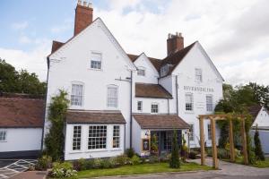 uma casa branca com um sinal para a estalagem de madeira em Riverside Inn by Chef & Brewer Collection em Shrewsbury