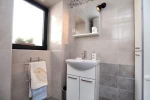 La salle de bains est pourvue d'un lavabo blanc et d'un miroir. dans l'établissement Studio apartman Mihaella, à Kaštela