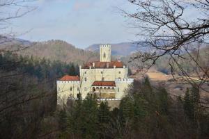 un gran edificio blanco con una torre en una montaña en Rooms Funda Lepoglava en Ivanec