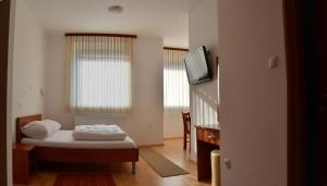 een kleine kamer met een bed en een televisie bij Rooms Funda Lepoglava in Ivanec