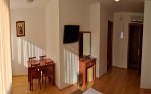 a living room with a table and a tv on a wall at Rooms Funda Lepoglava in Ivanec