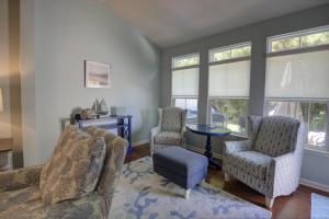a living room with two chairs and a table and windows at 36528 Putter Ln, Frankford in Frankford