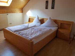 a bedroom with a bed with white sheets and pillows at Duschlwirt in Ampfing