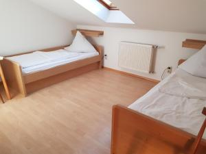 a small room with two beds and a skylight at Duschlwirt in Ampfing
