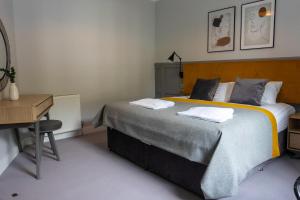 奧本的住宿－Airds Apartments，一间卧室配有一张大床和一张书桌