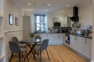 a kitchen with a table and chairs in a kitchen at Airds Apartments in Oban