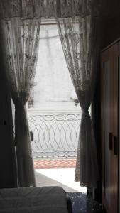 a window with curtains in a bedroom with a gate at B&B CASAVACANZE CHIESA MADRE in Carovigno