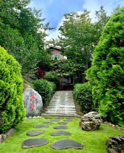 un jardín con un camino de piedra en el césped en Lala Maple Villa, en Hualing