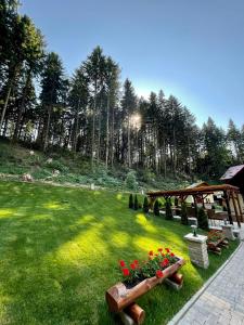 a park with benches and flowers in the grass at Boutique Hotel Casa Emil in Poiana Brasov