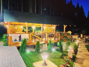 a building with a restaurant with lights in the grass at Boutique Hotel Casa Emil in Poiana Brasov