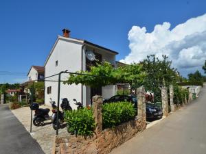 a white house with two motorcycles parked in front of it at Apartments Suki in Rovinj