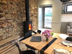 a living room with a fireplace and a wooden table at le penty plougonvelin in Plougonvelin
