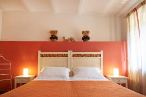 een slaapkamer met een bed met een oranje muur bij Affittacamere La Piazzetta in Orvieto