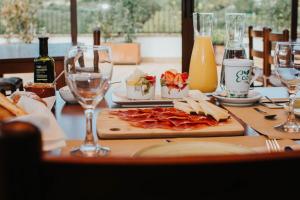 una mesa con un plato de comida y copas de vino en Hotel La Sitja - Adults only, en Benisoda