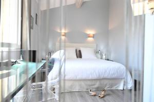 a bedroom with a white bed and a glass table at A 5 minutes du centre à pied, @lamaisonauxcanards in L'Isle-sur-la-Sorgue