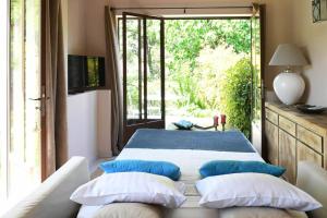 a bedroom with a bed with blue and white pillows at A 5 minutes du centre à pied, @lamaisonauxcanards in L'Isle-sur-la-Sorgue