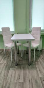 2 Stühle und ein weißer Tisch in einem Zimmer in der Unterkunft Студія з сучасним ремонтом in Kiew