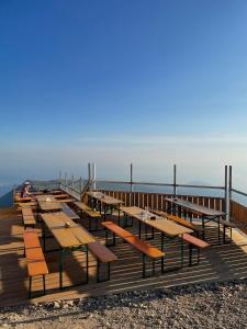 een houten pier met tafels en stoelen op het strand bij Rifugio Chierego - 1911m in Brenzone sul Garda