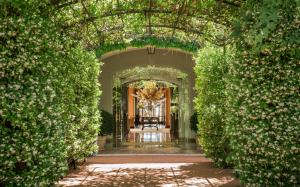 an entrance to a building with an arch with flowers at Ch&acirc;teau Saint-Martin & Spa - an Oetker Collection Hotel in Vence
