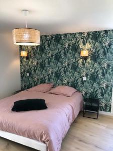 um quarto com uma cama grande e uma parede verde em le penty plougonvelin em Plougonvelin