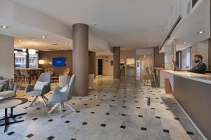 a man sitting at a bar in a hotel lobby at Catalonia Bristol in Sant Andreu de la Barca