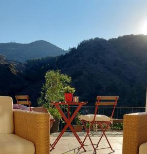 una mesa y sillas en un patio con una montaña en BELLE VUE Mountain Home, en Kalopanayiotis