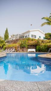 einen Pool mit blauem Wasser vor einem Haus in der Unterkunft Vila da Falésia-With Pool and views in Caniço