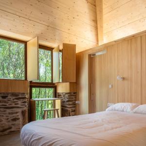 1 dormitorio en una casa con cama y ventanas en Abeiro da loba, 