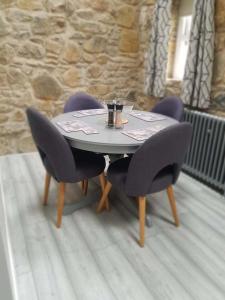 einen Tisch mit zwei Stühlen und einen Tisch mit einem Getränk darauf in der Unterkunft Cobbles cottage - 2 bedroom stone built cottage in Ballynahinch