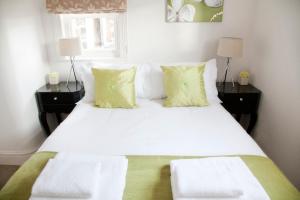 1 dormitorio con 1 cama blanca grande con almohadas amarillas en Valley View, en Harrogate