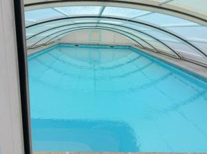 a large swimming pool in a building with a ceiling at Chambre Arnica lit 140 wifi sdb partagée in Saint-Amarin